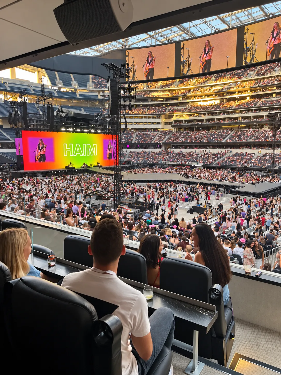 Guests in a private stadium suite overlooking a sold-out arena concert
